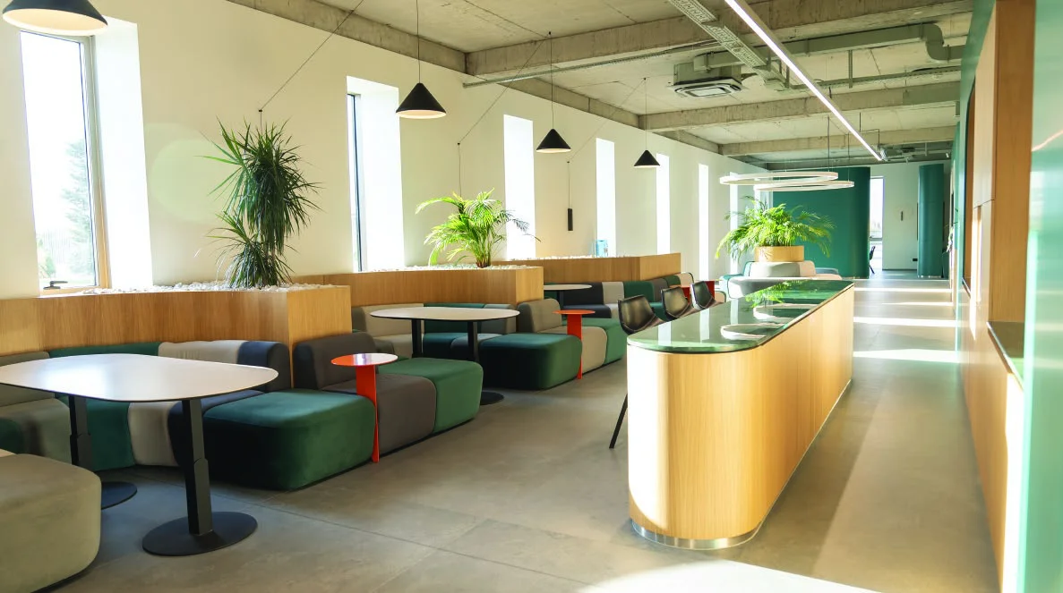 Dining area with shared seating, plants and green upholstery