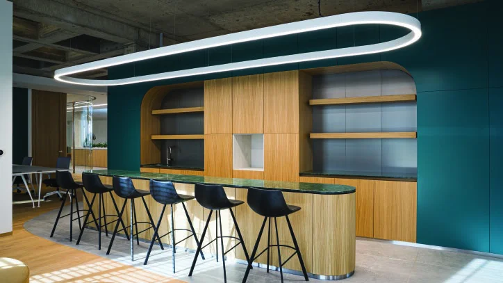 Collaboration lounge with high tables and open shelving