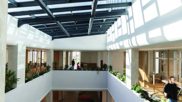 Bright shared workspace and central atrium with a glazed roof
